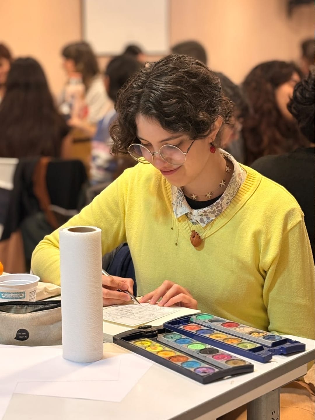 Elena pintando con acuarelas en su cuaderno